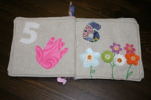 I fused the handprint on, cut from pink flannel.  The flowers are scrapbooking supplies, with button centers and embroidered stems.